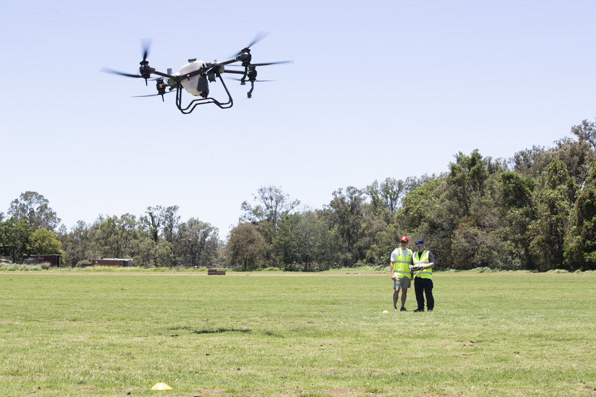 Student controlling drone in flight with teacher observing