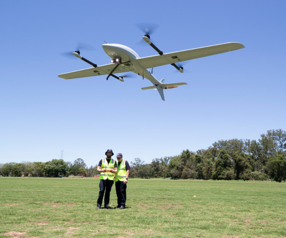 Drone hovering with trees in the background